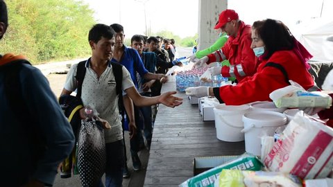 Volunteers from Red cross distributing help for refugees in Hungary - Austria border. These refugees are from Syria, Iraq and Afghanistan and they will go to Germany. October 6, Hegyeshalom, Hungary