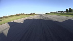 Bumpy, intense forward runway view, 4k takeoff in private aircraft, casts fast shadow.