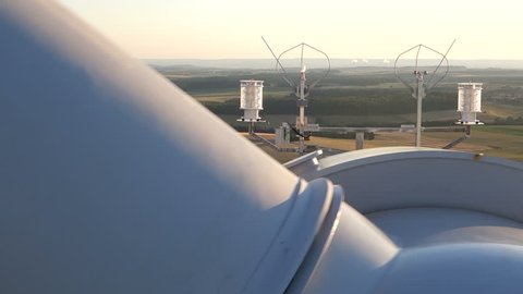 Wind turbines create renewable energy in Germany. Cooling tower of nuclear power plant in background.