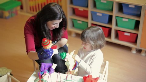 School: girl and teacher playing with marionette in kindergarten. Sequence