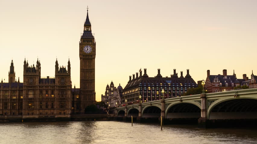 Zoom out, Sunset to night time lapse of the Houses of Parliament and Big Ben clock tower with Westminster Bridge and River Thames, London, UK