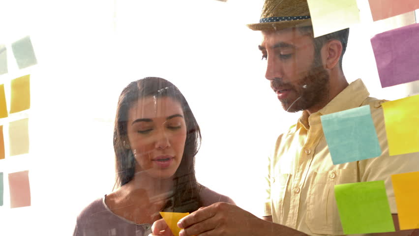 Business team looking at post it in office