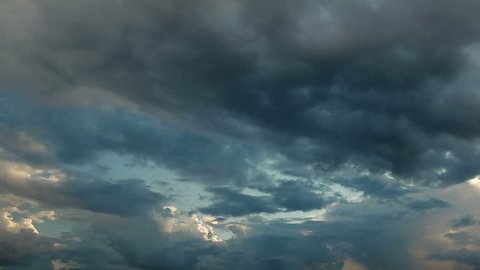 Clouds running across the rapidly darkening sky at sunset. Timelaps