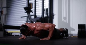 An athlete doing extreme push ups at a gym. Shot on RED Epic.