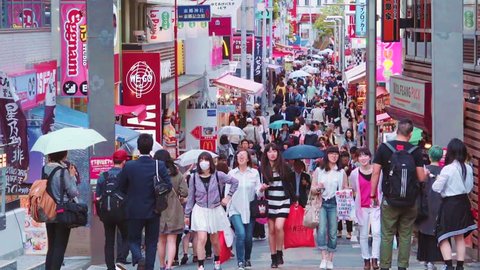 TOKYO - CIRCA JUNE 2015: People walk and shop along Takeshita Street in Harajuku, Tokyo, Japan. Takeshita is a pedestrian-only street lined with cafes and boutiques famous for its fashion trends.