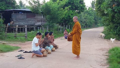 Sakon Nakon , North East Thailand, on October 6th 2015: Thai Buddhist Monks walk barefoot in early morning and collect food and give blessings to local villagers at Sakon Nakon , North East Thailand, on October 6th 2015.  Filmed in 4K.