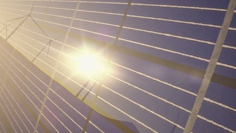 1080p stock video of a camera pan of solar panels and wind turbines in the desert.