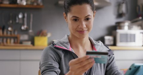 Beautiful mixed race woman shopping online with credit card using digital tablet connected banking app