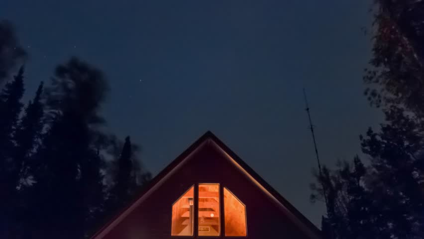 4K Stars Behind a Glowing Cabin