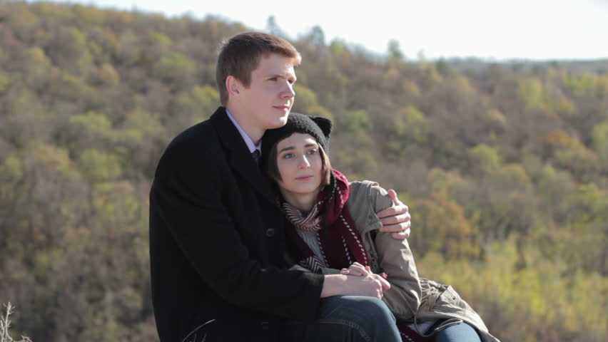Young couple in the mountains enjoying life and talking 