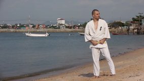 Karate Video Oriental Martial Art Stock Video Footage Man on the beach practicing, he does exercise. Behind him ships, seascape, sky, summer hdv Static, Hd, Hidef, Fx, Definition, High