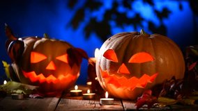 Halloween pumpkin head jack lantern with burning candles over black background. Halloween holidays art design, celebration. Stock video footage HD 1080p 