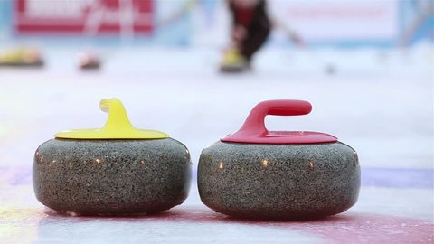 Stones For curling collide on the ice. Players curling throw stones on the ice.