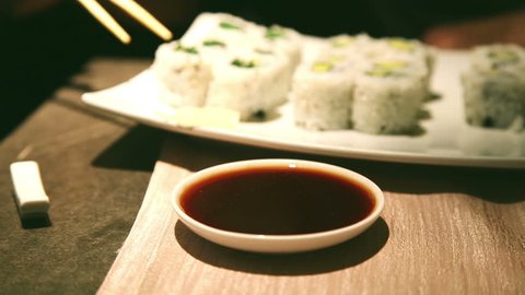 a close up of sushi vegetarian roll soaked in soy sauce in a sushi bar స్టాక్ వీడియో