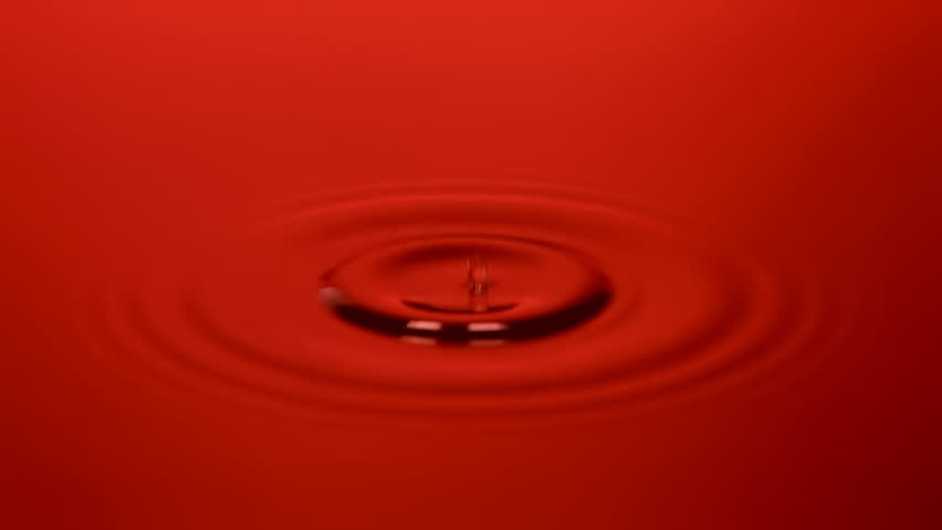 Water drops falling endlessly into red water leaving lovely ripples. Sequence
