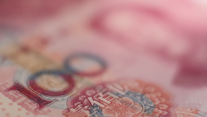 Rack focus across Chinese 100 Yuan note settling on eyes of Chairman Mao Zedong