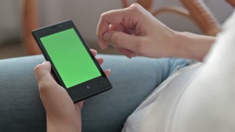 Woman hands touching and scrolling smartphone.green screen display Stock Video