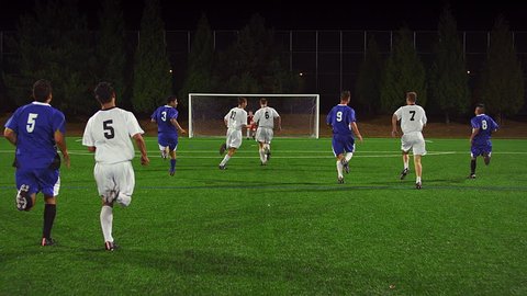 The camera follows a soccer player down the field as he makes a goal