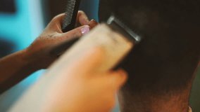 Barber cuts the hair of the client with clipper.