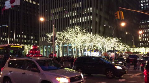 NEW YORK CITY - Dec. 2014: Chase Manhattan bank gets into Christmas spirit by adding big red Christmas ornaments to their fountain. People gather on corner with holiday lights on trees with traffic.