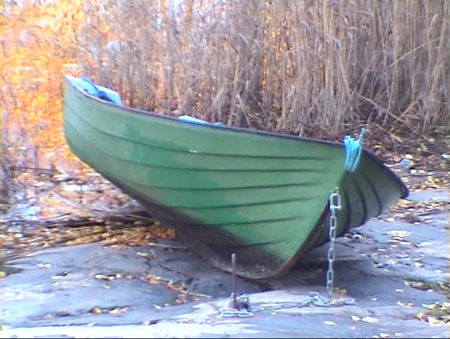 Rowing boat on a rock shore at sunrise
