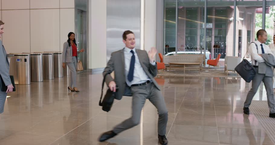 Crazy happy businessman dancing in corporate lobby wearing suit celebrating achievement Royalty-Free Stock Footage #12322181