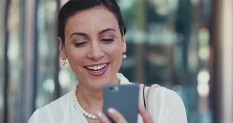 Portrait of Middle Eastern Businesswoman smiling outside corporate office building using smartphone
