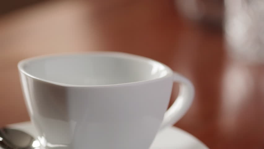 Close up of pouring coffee into white cup
