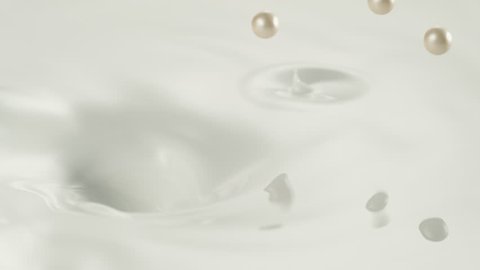 Pearls falling into cream swirl. Shot with high speed camera, phantom flex 4K. Slow Motion. Unedited