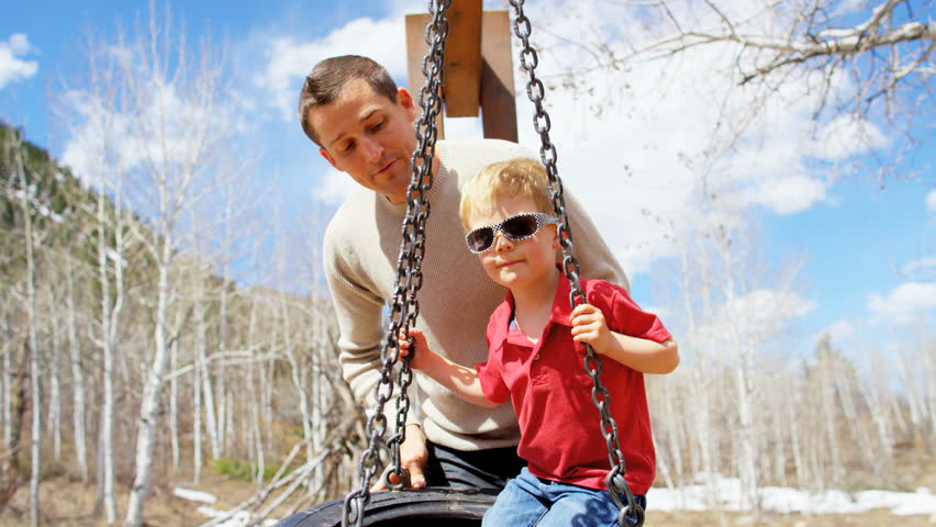 portrait leisure Caucasian family father child America USA outdoor park vacation togetherness advertisement relaxation playing swing RED DRAGON