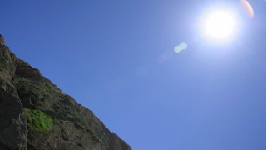 Man pressing heavy log over head with mountain in background