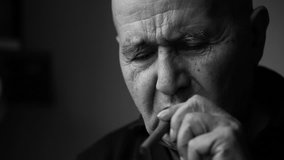 Old man smoking a cigar black and white video closeup.