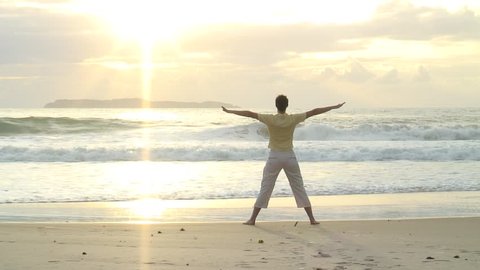 HD 1080i: Young woman doing yoga on the beach at sunrise in Bombinhas - Brazil. Tripod.