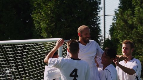 A soccer team celebrates after making a goal