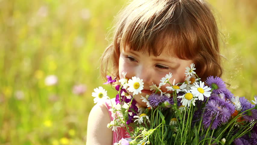 Little girl with flowers laughing 