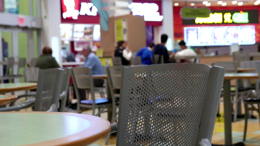 People enjoying meal in modern mall food court cafeteria, focus on chair with 4k resolution