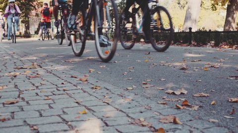 Steadicam shot of group of cyclists lower bodies peddling fast on a bicycle road. 4K Ultra HD, UHD. Healthy lifestyle in the city. Sports and active life. Close up bicycle wheels. Unrecognizable. 