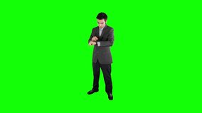 Businessman using a smartwatch on his wrist on a green screen chroma key background easy to replace with your content. Shot in 4K UHD resolution. - Powered by Shutterstock - Get 15% off with code: PIKWIZARD15