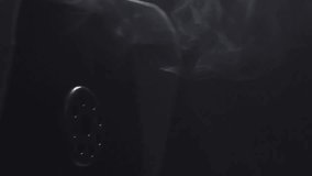 Smoke machine in action on black background, slow motion video