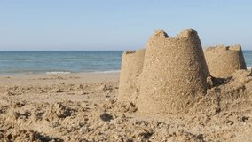 Sand towers on the oceans beach summer theme background 4K 3840X2160 30fps UHD footage - Castles made of sand and sea waves in background close-up 4K 2160p UltraHD video