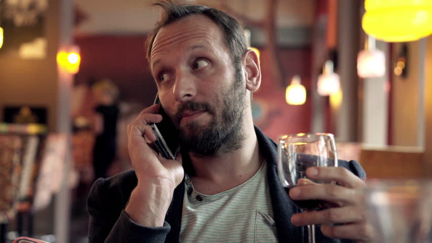 Young man drinking wine and talking on cellphone at the bar
 | Shutterstock HD Video #12363434