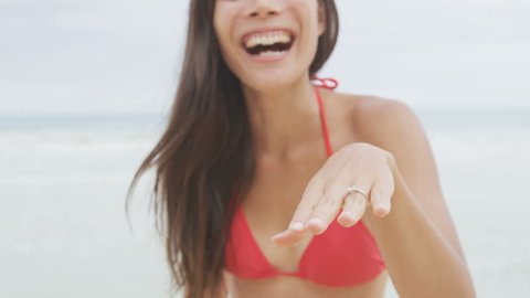 Woman showing Engagement Ring on beach after marriage proposal. Excited happy cute girl in wedding concept on Hawaii laughing having fun in bikini during holiday travel. RED EPIC SLOW MOTION