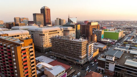 Medium timelapse at sunset/nightfall showing the view across New Town.  Johannesburg during peak traffic with people in the streets, buildings and taxis(Johannesburg, South Africa - 09/06/2015)
