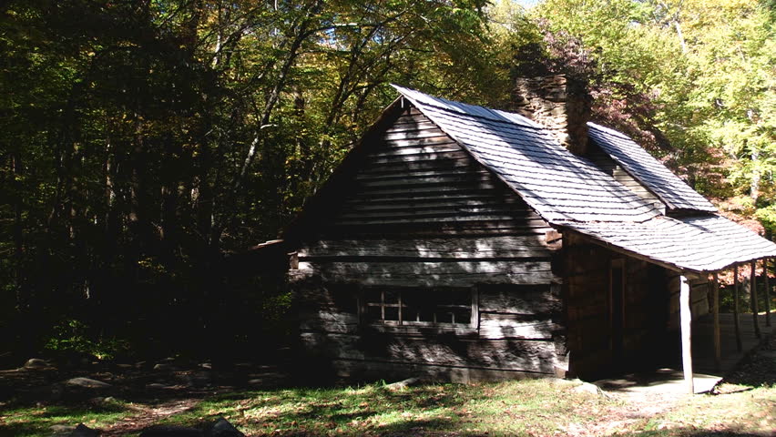 Rustic cabin in early autumn in the Great Smoky Mountains with dark shadows and some autumn color