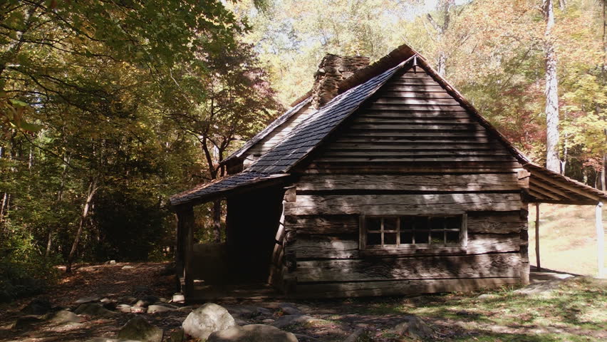 Rustic cabin in early autumn in the Great Smoky Mountains with dark shadows and some autumn color