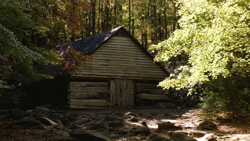 Rustic cabin in early autumn in the Great Smoky Mountains with dark shadows and some autumn color