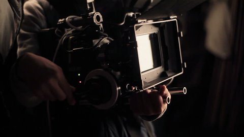Cameraman adjusting camera before filming. Shooting with red camera. Close-up