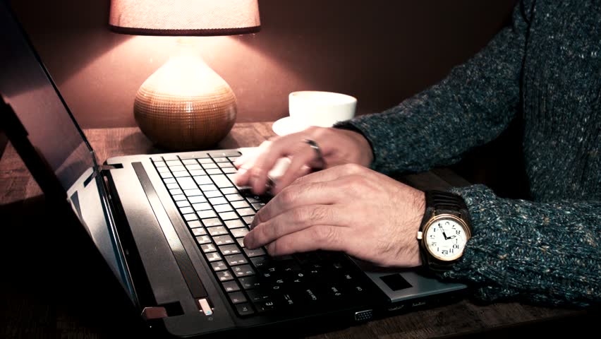 Hands working at a laptop and take a cup
