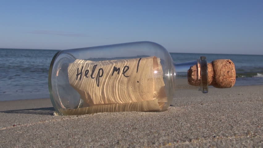 Vintage bottle with a message on ocean beach - help me