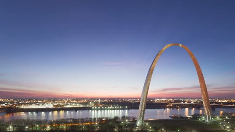 4K Time lapse aerial view St Louis Gateway Arch at sunrise with boat traffic on the river and red colored clouds